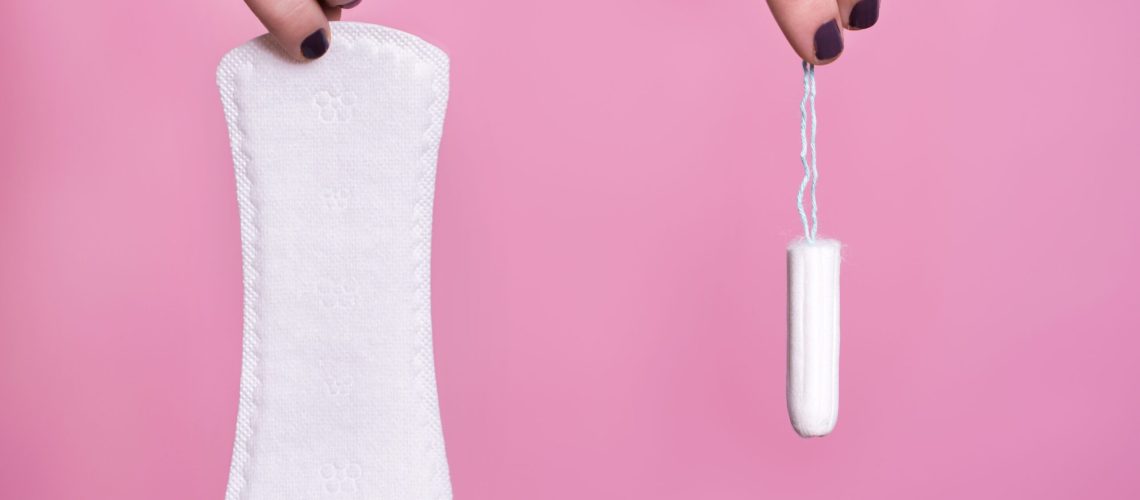 Women holding a sanitary napkin and tampon